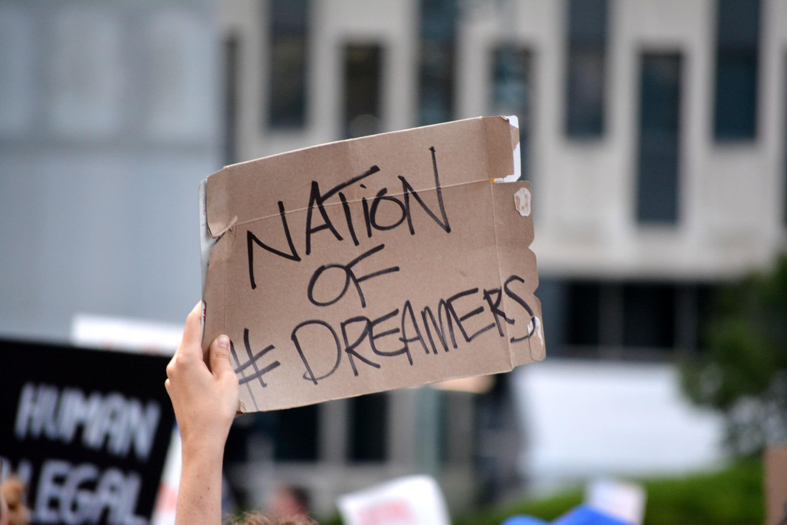 a hand holding a sign reading nation of dreamers