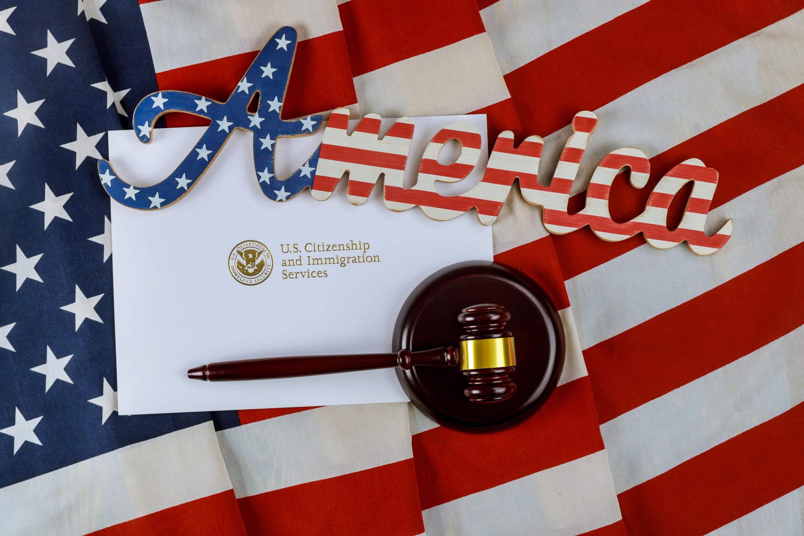 a gavel next to an envelope labeled us citizenship and immigration services